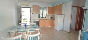 a kitchen with a table and chairs and a refrigerator at THALASSA - 2 Bedroom seaside appartment in Polychrono +5 photos