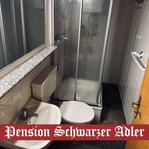 a bathroom with a shower and a toilet and a sink at Pension Schwarzer Adler 