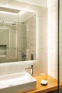 a bathroom with a sink and a mirror at Danae Hotel in Egina