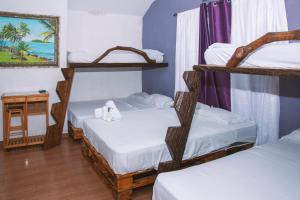 a room with three bunk beds and a table at HOSPEDAJE VILLAMAR in Nueva Gorgona