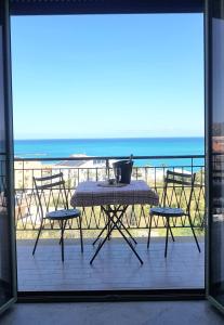 a table and chairs on a balcony with a view of the ocean at La Finestra sul Golfo in Castellammare del Golfo