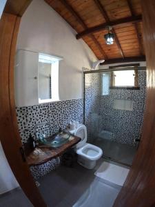 a bathroom with a toilet and a sink and a shower at Chalés Vila Real - Tranquilidade na Serra de Carrancas - Piscina com uma vista espetacular do Pôr do Sol in Carrancas