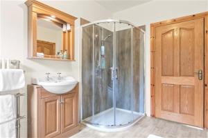 La salle de bains est pourvue d'une douche et d'un lavabo. dans l'établissement Dunhill Cottage B&B, à Hillsborough