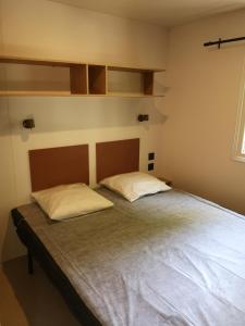 1 dormitorio con 1 cama con 2 almohadas en Camping Le Fou du Roi, en Lansargues