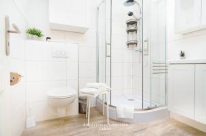 a white bathroom with a shower and a toilet at Wiesenweg Wo8 in Laboe
