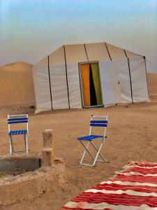 2 Stühle und ein Zelt in der Wüste in der Unterkunft Nomad Life Style in M’hamid El Ghizlane