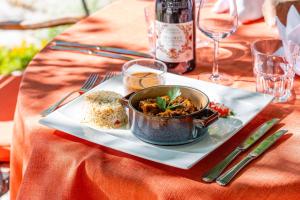a table with a bowl of food on a plate at Hotellerie du Domaine de Cabasse in Séguret