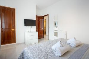 a white bedroom with a bed with towels on it at Blife Allya private rooms in Faro