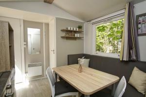 a dining room with a wooden table and chairs at Tiny Chalet Nr 814 in Göhren