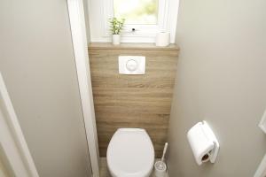 a small bathroom with a toilet and a window at Tiny Chalet Nr 814 in Göhren