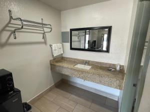 a bathroom with a sink and a mirror at Budget Inn Ada in Ada