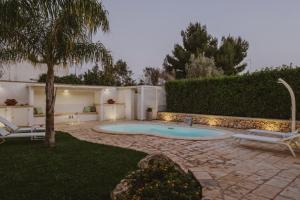 a backyard with a swimming pool with a palm tree at Villa Patrizia Salento Art & Room in Porto Cesareo