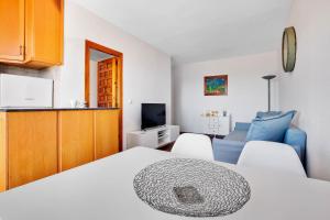 um quarto com uma cama e 2 cadeiras brancas em Edificio Carihuela By IVI Real Estate em Torremolinos