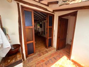 um corredor com portas de madeira numa casa em EcoHotel Barichara em Barichara