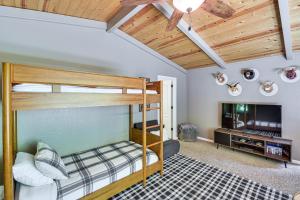 1 dormitorio con 2 literas y TV de pantalla plana en The Cub House | Arnold Cabin with Hot Tub and Arcade!, en Arnold