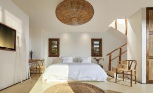 um quarto com uma cama, uma mesa e cadeiras em Villa Praia - La Villa Group em Jericoacoara