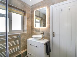 a bathroom with a sink and a mirror at Harvest Moon Cottage in Bishops Frome
