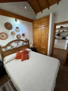 1 dormitorio con cama blanca y armarios de madera en Casa Rural Quilla en Agulo