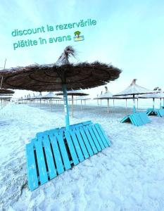 a blue beach chair with an umbrella on the beach at FERNWEH No 5 Boutique Hotel MAMAIA Nord in Mamaia Nord