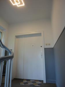 einen Flur mit einer weißen Tür und einer Treppe in der Unterkunft Ferienwohnungen Stella, Adrián in Saarbrücken
