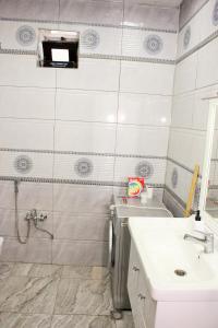 a bathroom with a sink and a toilet and a mirror at Famili home in Ganja +6 photos