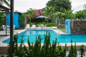 - une piscine avec des chaises, une table et un parasol dans l'établissement HOSPEDAJE VILLAMAR, à Nueva Gorgona