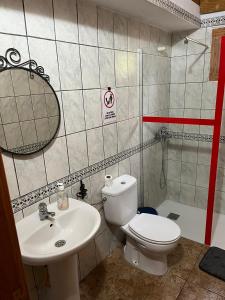 La salle de bains est pourvue de toilettes blanches et d'un lavabo. dans l'établissement Casa Rural Quilla, à Agulo