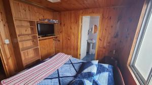 niewielka sypialnia z łóżkiem i telewizorem w obiekcie CASA DE HUÉSPEDES JEM w mieście Bucalemu
