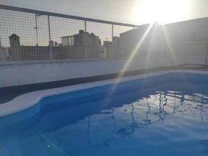 una piscina azul con el sol en el fondo en Apartamento Centro Judería, en Sevilla