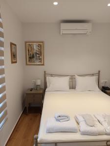 a bedroom with a white bed with towels on it at Lythri Studios in Chios