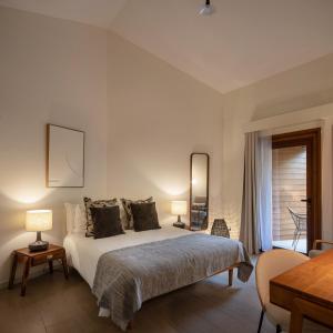 - une chambre avec un lit avec deux lampes et une table dans l'établissement Alma do Pico - Nature Residence, à Madalena