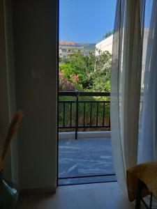 a door open to a balcony with a view of a yard at Cozy Karystos Apartment in Karistos