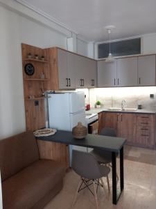 a kitchen with a table and a couch and a refrigerator at Cozy Karystos Apartment in Karistos