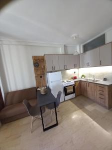 a small kitchen with a table and a couch at Cozy Karystos Apartment in Karistos +9 photos