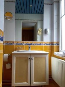 La salle de bains est pourvue d'un lavabo et d'un miroir. dans l'établissement Hotel de Normandie, à Évreux