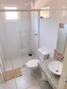 a bathroom with a shower and a toilet and a sink at Hotel Paradouro - Com Café da Manhã in Alfredo Wagner +36 photos
