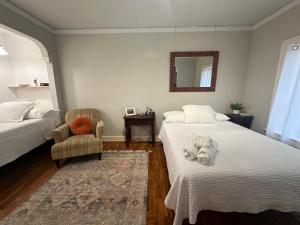 1 Schlafzimmer mit 2 Betten, einem Stuhl und einem Spiegel in der Unterkunft The Vurpillat in Hermosa Beach