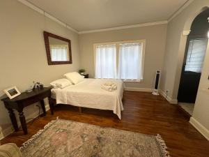 a bedroom with a bed and a table and a window at The Vurpillat in Hermosa Beach