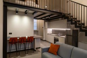 a kitchen and living room with a staircase in a loft at La Villa Viale Verdi in Novara