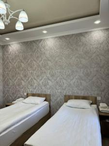dos camas sentadas una al lado de la otra en un dormitorio en Айкол, en Bokonbayevo