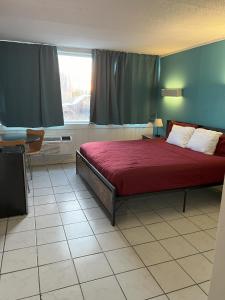 錫賽德海茨的住宿－AIRE Hotel North Beach Jersey Shore，一间卧室配有一张带红色棉被的床和窗户。