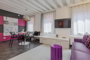 eine Küche und ein Wohnzimmer mit einem Tisch und Stühlen in der Unterkunft Tadomo - Corte del Cafetier in Venedig