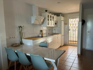 a kitchen with a table and some blue chairs at Luxury Hacienda Golf Islantilla in Islantilla