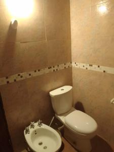 a bathroom with a white toilet and a sink at Cabaña de campo Secretos de la Naturaleza in San Juan