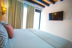 a bedroom with a bed with a television on the wall at Hotel Tropicus Boutique in Puerto Vallarta