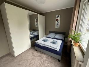 una piccola camera con letto e specchio di Entspannung am Niederrhein - großes helles Haus mit Kamin a Emmerich am Rhein