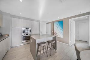a kitchen with a counter and stools in a room at Wake Up To Ocean Views - Stunning 2BDR & 2BA Condo STEPS AWAY FROM THE OCEAN, NO RESORT & PARKING FEES, CHECK DETAILS in Hollywood