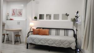 - une chambre avec un lit doté d'oreillers orange et d'une table dans l'établissement Estudio Horta, à Barcelone