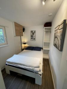 a small bedroom with a bed and a shelf at Chalet Pallegarste 125 in Mariënberg