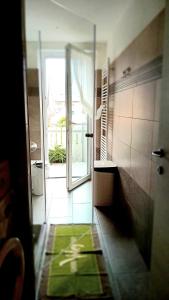 een open deur naar een badkamer met een groen tapijt bij Appartment Lodged Mamma Maria in Mattarello